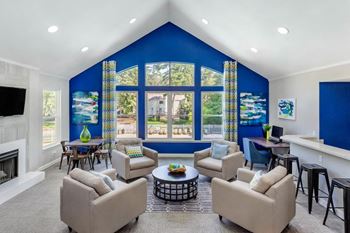 Clubhouse seating area with grey armchairs around coffee table